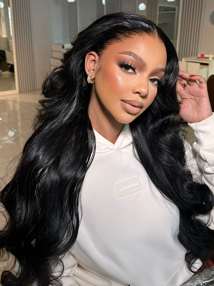 Woman with long, glossy black wavy hair wearing a glueless ready-to-go wig