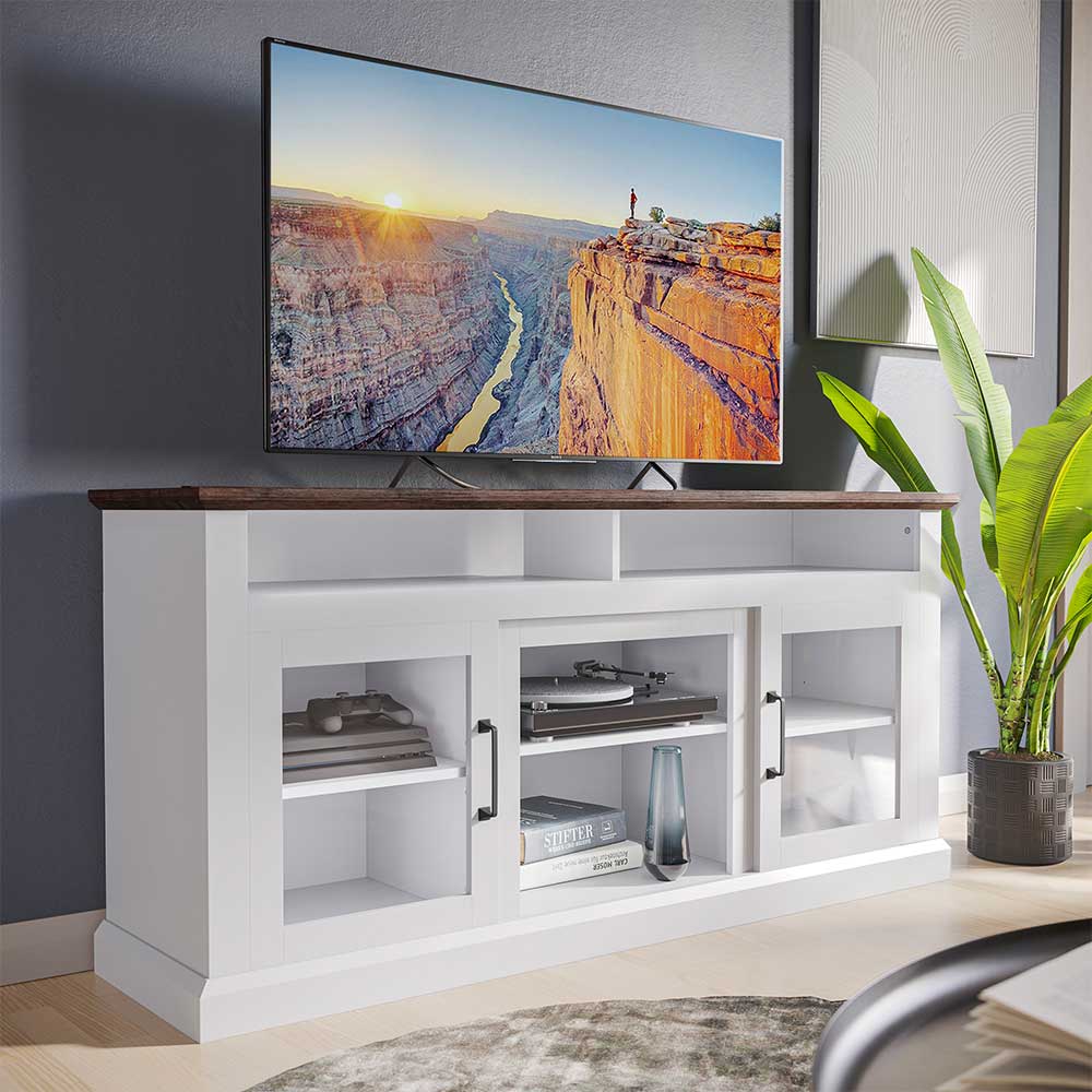 White Belleze Cayman TV stand with glass doors, open shelves and a wood-tone top holding a television