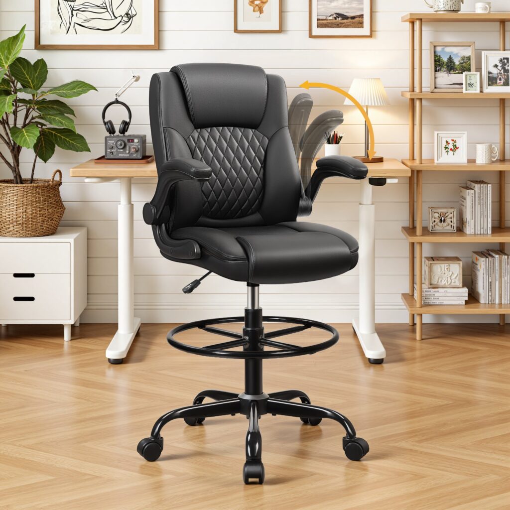 Black PU leather office chair on a tall base with a footrest ring, next to a standing desk in a bright home office