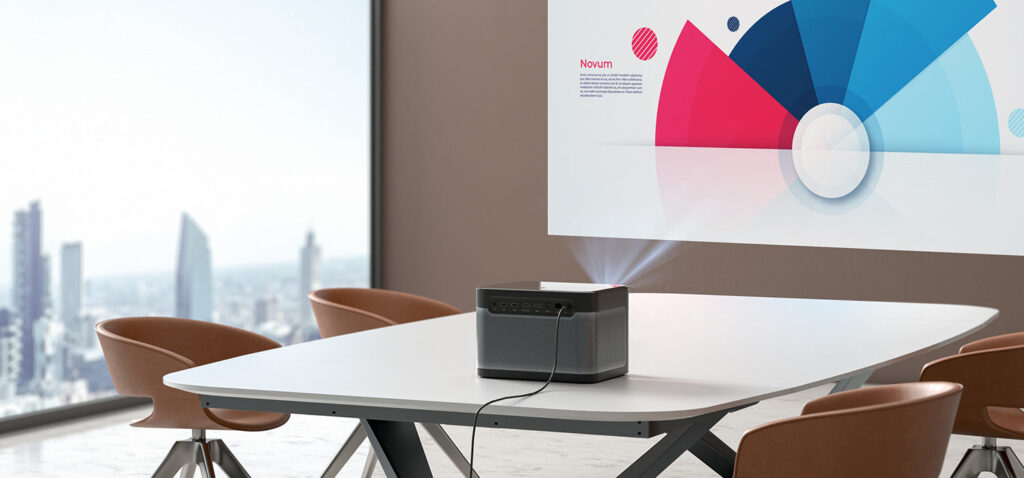 Rear of a Dangbei DBOX02 on a conference table projecting a presentation onto the wall