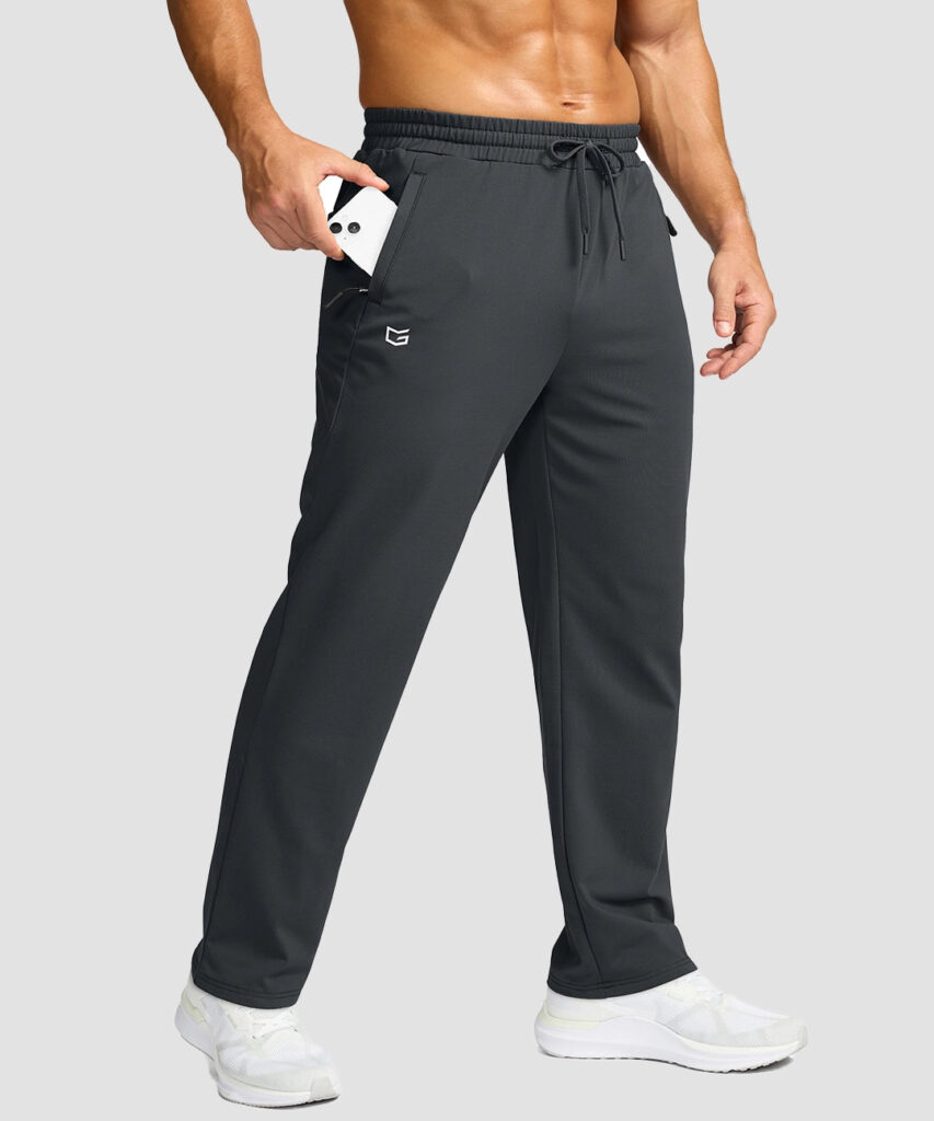 Man slipping a phone into the zippered side pocket of dark gray G Gradual Mid-Rise Fleece-Lined Track Pants