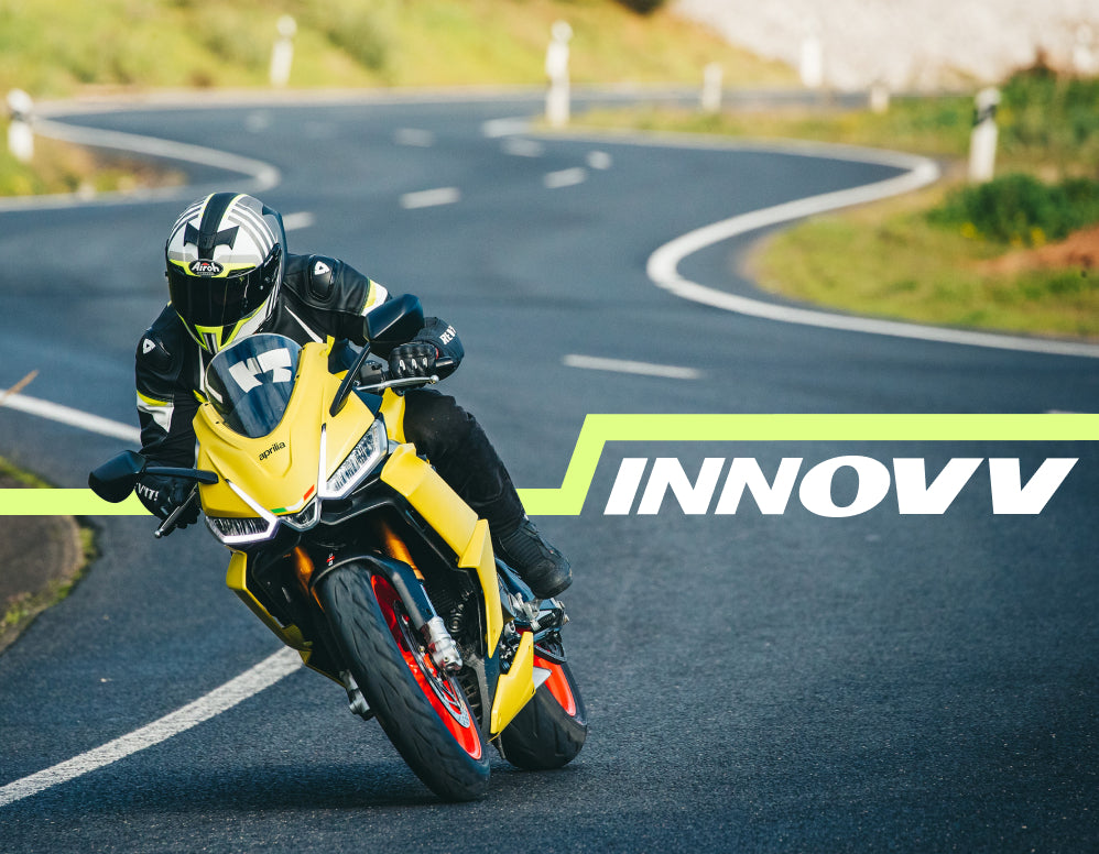 Rider leaning a yellow sport bike through a curve on a winding road beside the INNOVV logo
