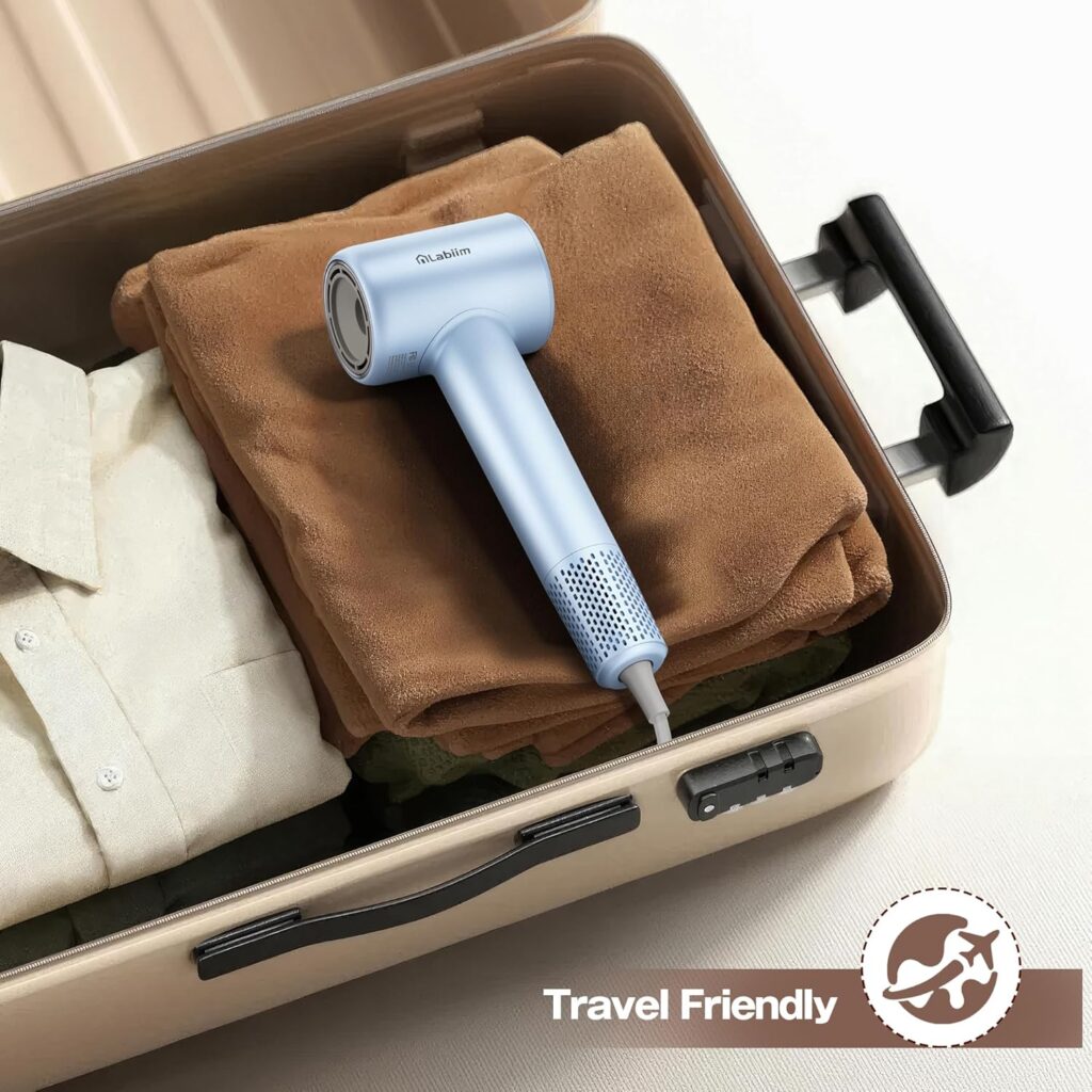 Blue Labiim hair dryer packed in an open suitcase on top of folded clothes