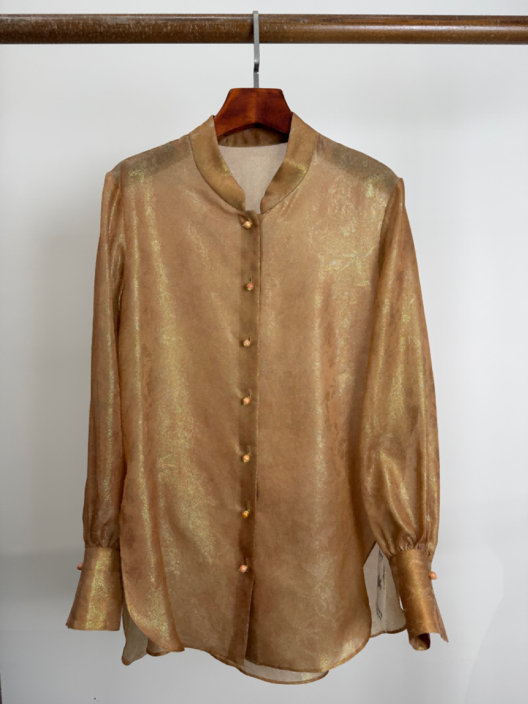Champagne silk jacquard blouse on a hanger, showing the mandarin collar, button front and cuffed sleeves