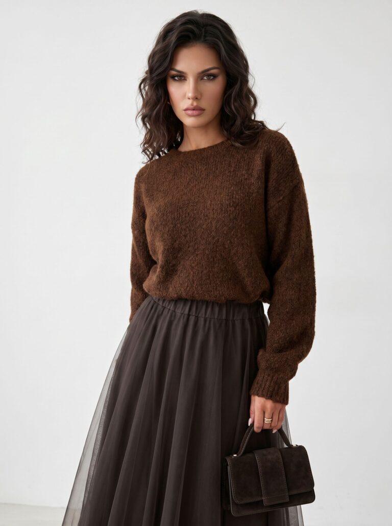Oversized brown knit sweater styled with a dark tulle skirt and a small suede handbag