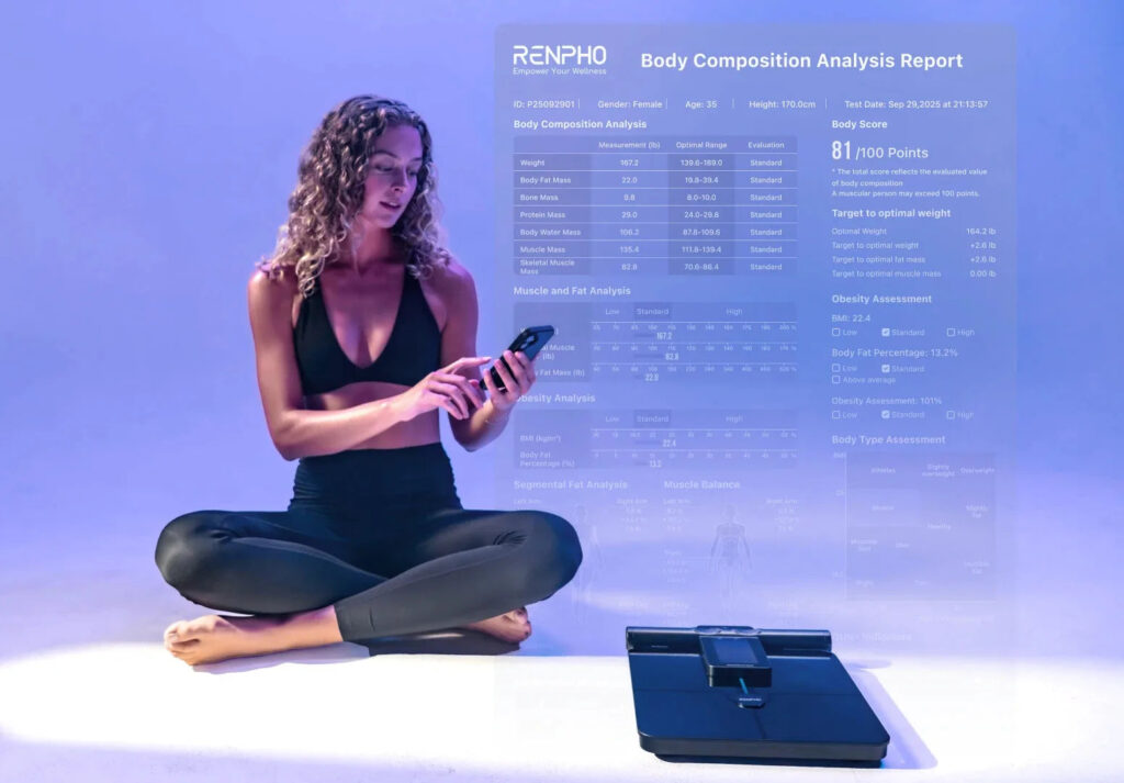 Woman checking a body composition report on her phone beside the MorphoScan Nova scale