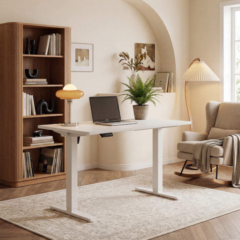 White Sweetcrispy electric standing desk in a home office corner with a bookshelf and an armchair