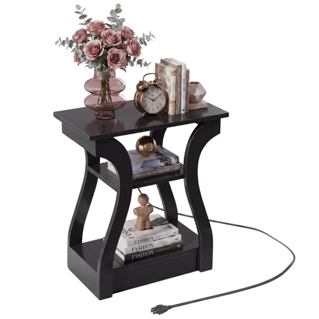 Black three-tier end table with curved sides and a power cord, styled with flowers and books