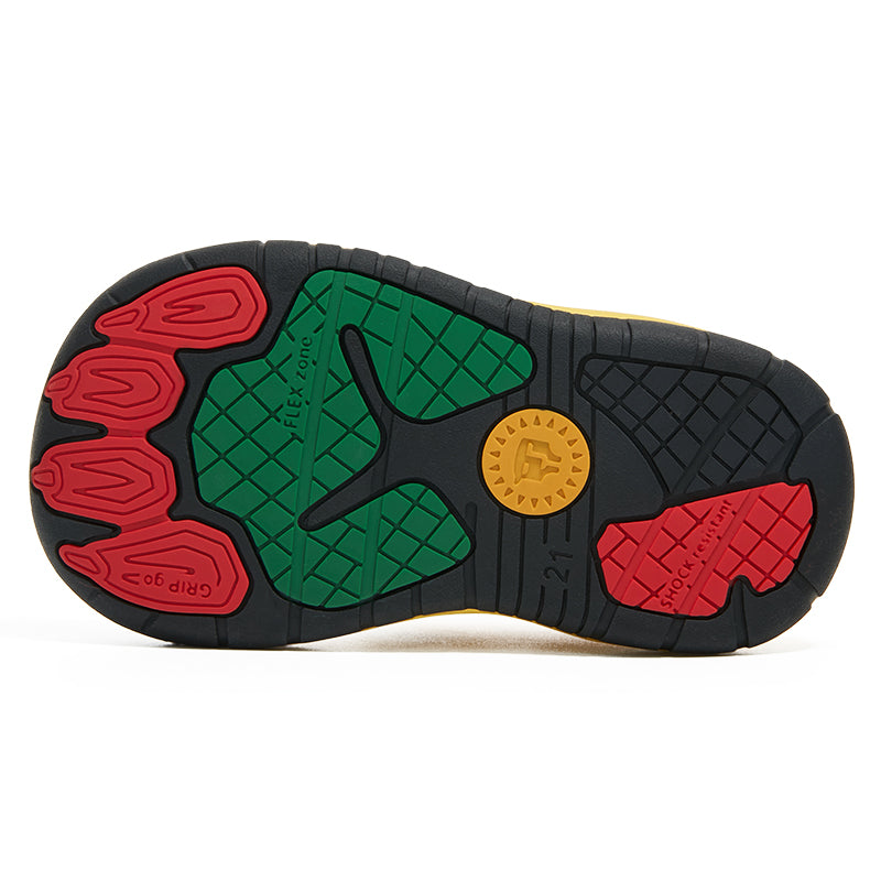 Underside of a yellow Taranis toddler shoe showing the black rubber outsole with red, green and yellow tread zones