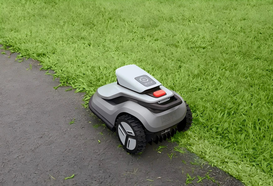 TerraMow robot mower cutting grass along the edge of a paved path