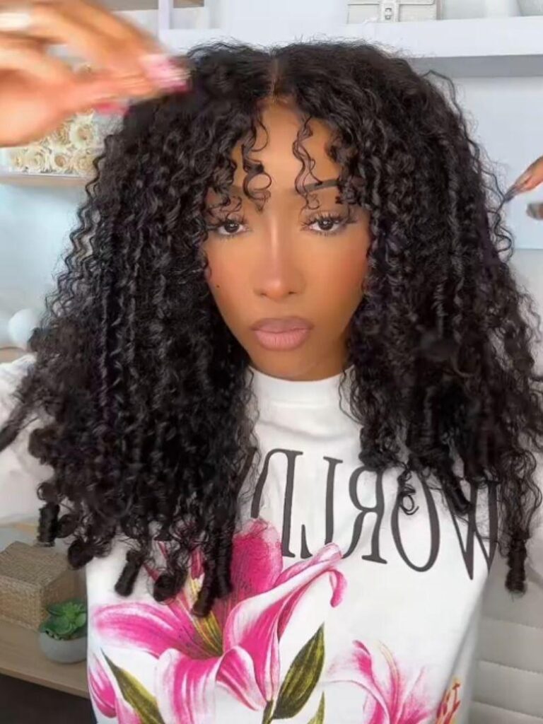 Woman with a curly UNice Bye-Bye Slip drawstring wig, parting the front of her hair with her fingers