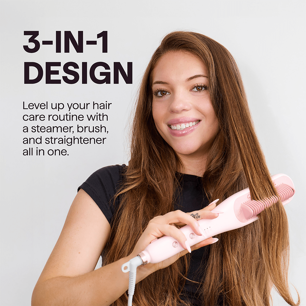 A woman with long auburn hair smiling while holding the pink Wavytalk Steamline Pro steam brush against her hair