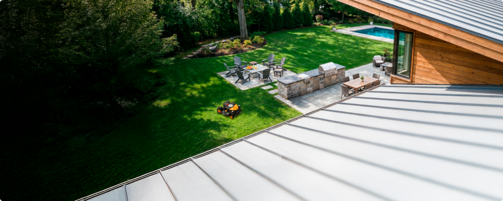 Aerial view of a landscaped backyard with a WORX Landroid robot mower working on the lawn