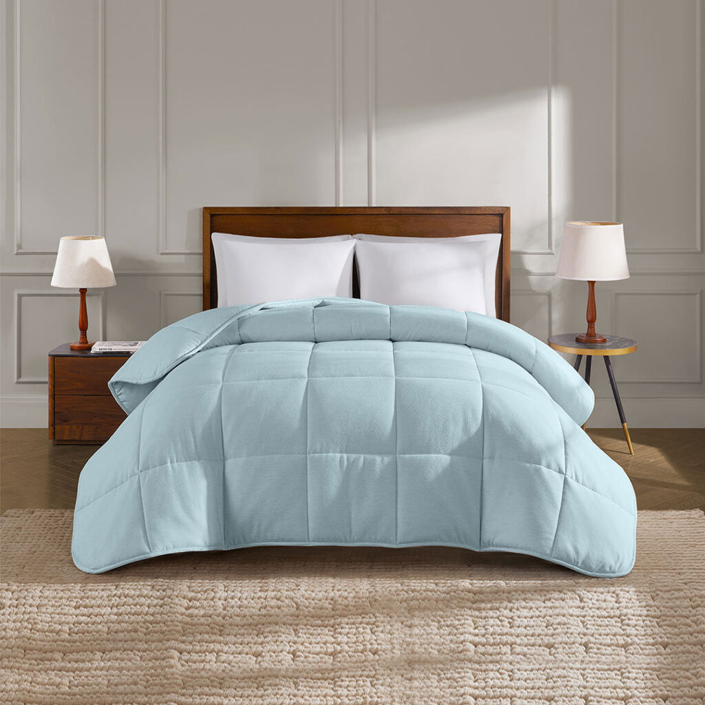 YNM Home weighted comforter in Mist Blue on a made bed with white pillows